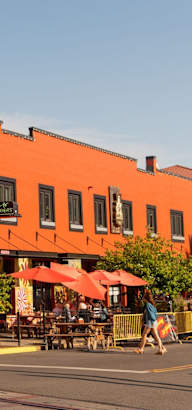 A street view of a building with a red and orange facade.
