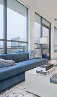 a living room with a couch coffee table and a kitchen in the background at Tapestry West in Richmond, VA