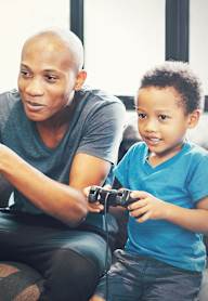 a mother and father sit on a couch with their children