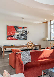 a living room with a red couch and a glass table