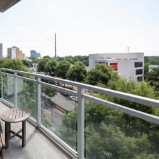 a balcony with a chair and a view of the city