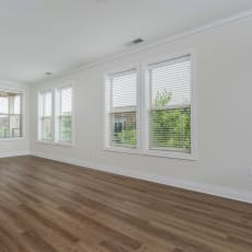 a bedroom with hardwood floors and white walls