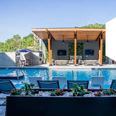 a swimming pool with blue chairs and a pool house with a graphic at Sterling Nashville West Apartments, Nashville, 37209
