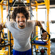 a man smiling while using the gym equipment at the gym