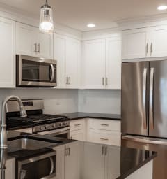 a kitchen with white cabinets and stainless steel appliances at Zephyr Ridge Apartment Homes, Cedar Grove