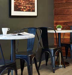 a table and chairs in a restaurant  at 888 Hilgard – Furnished Apartments, Los Angeles, CA