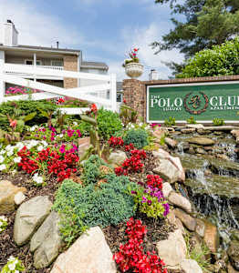 A garden with a waterfall and a sign that says Polo Club.