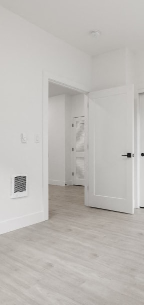 an empty living room with white walls and white doors