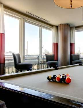 A pool table with a white ball and several others with red and yellow stripes on it.