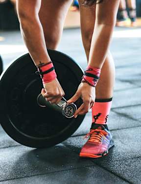 A person is lifting a barbell in a gym.