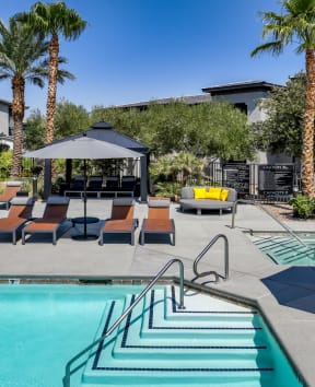 swimming pool  and poolside lounging areas at South Blvd apartments