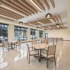 A large room with tables and chairs and a ceiling with wooden slats.