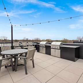 A patio with a table and chairs is set up on a rooftop.