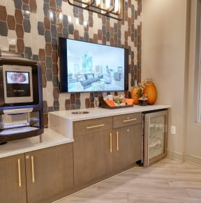 a kitchen with a tv on the wall and a dishwasher on the counter at Artistry at Winterfield Apartments, Virginia