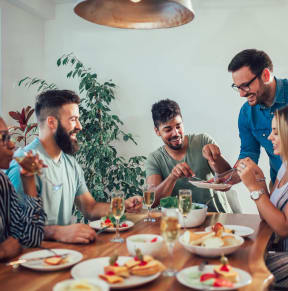 a group of people sitting around a table eating food