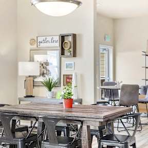 A dining room with a wooden table and chairs.