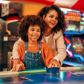 Mother and Daughter Playing Games at Arcade Together