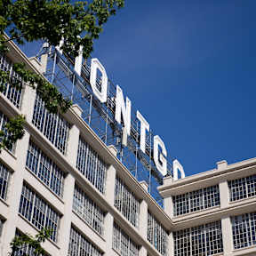 Tall Building with Windows and Sign on Top