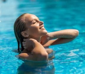 A woman is enjoying a swim in a pool.
