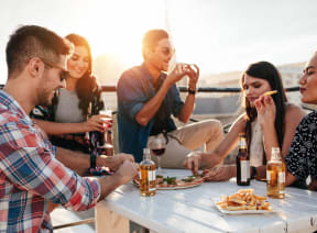 a group of people sitting around a table eating and drinking at The Lucky Apartments, Culver City, CA