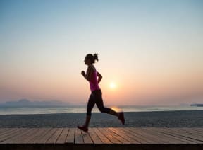 a woman running on a dock at the beach at sunset at The Lucky Apartments, Culver City, California