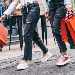 Friends Walking Together Holding Shopping Bags