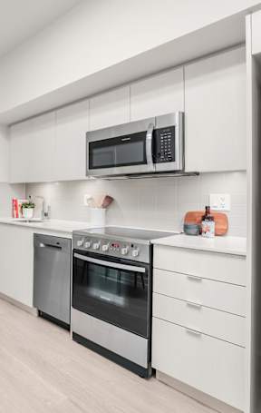 A kitchen with a black island and white cabinets.