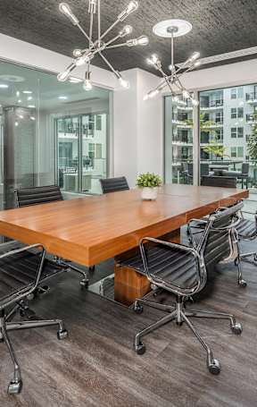 A conference room with a long table surrounded by chairs.