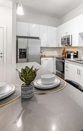 A modern kitchen with a stainless steel island and white cabinets.