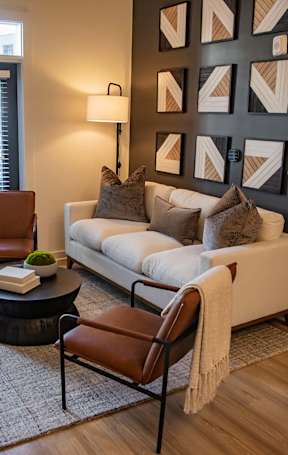 A living room with a white couch, a coffee table, and a lamp. at Sterling Nashville West Apartments, Nashville, 37209