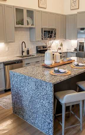 a kitchen with an island and a stainless steel refrigerator at Sterling Nashville West Apartments, Nashville, 37209