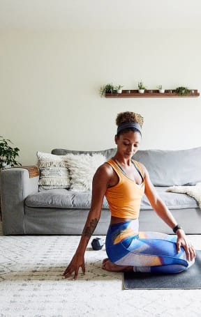 a woman sitting on a yoga mat in the middle of a living room at Sinclaire on Seminary, Alexandria, VA 22311