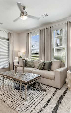 A living room with a grey couch, a coffee table, and a television.