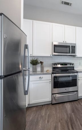 a kitchen with stainless steel appliances and white cabinets