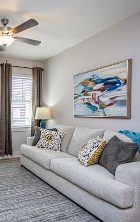a living room with a couch and a ceiling fan