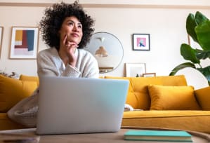 a woman sitting on a couch with her laptop computer