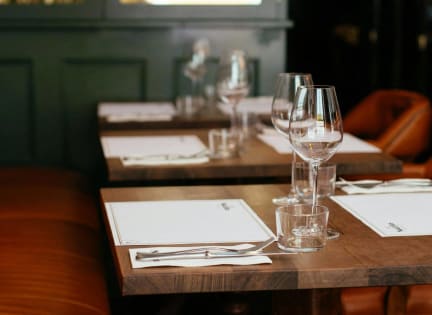 a restaurant table with wine glasses and menus