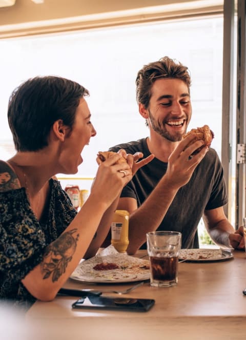 Friends Smiling while Having Lunch Together
