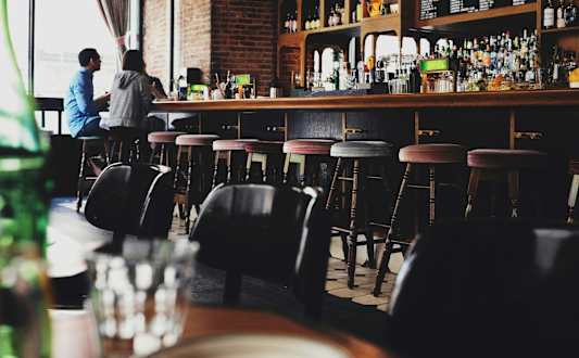 A bar with a person sitting at the counter.