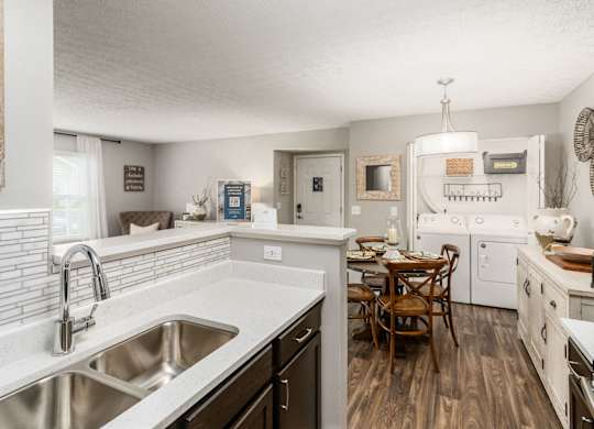 A kitchen with a table and chairs in the middle of it.