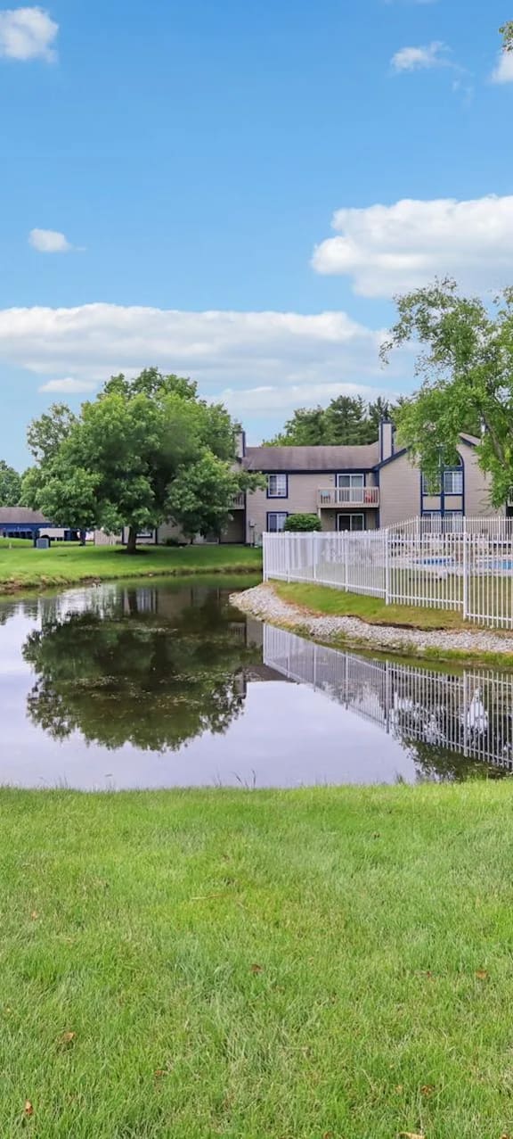 A pond in front of a row of houses.