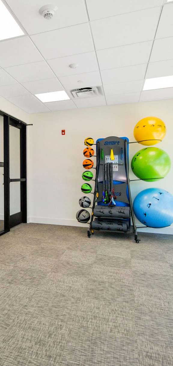 A room with a large screen on the wall and a treadmill.
