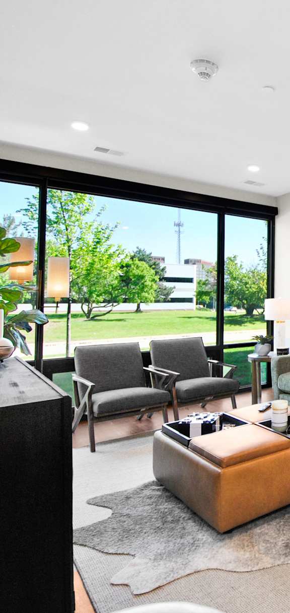 A living room with a green couch and a wooden floor.