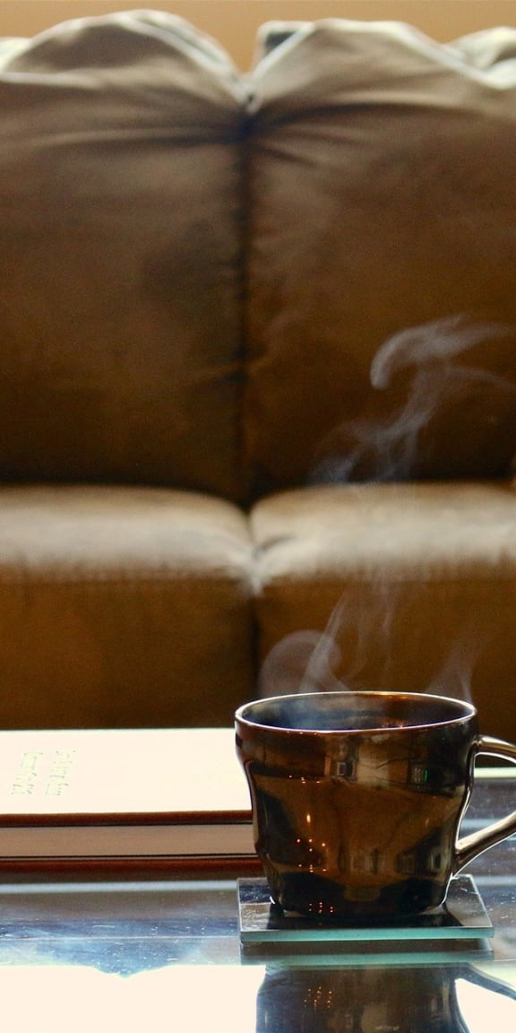 a cup of tea on a coffee table in front of a couch
