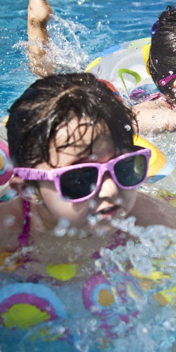 two girls swimming in a swimming pool