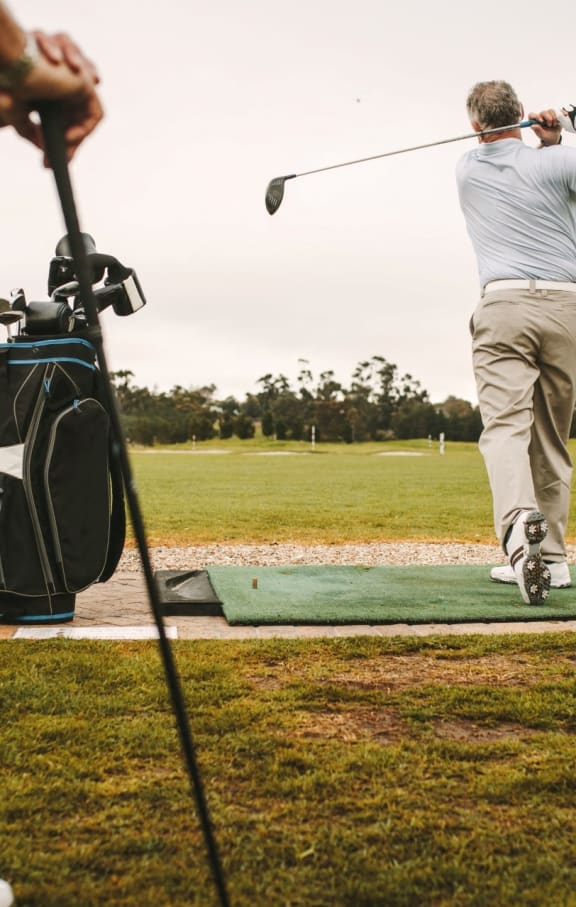 Men Golfing at Golf Course on Cloudy Day