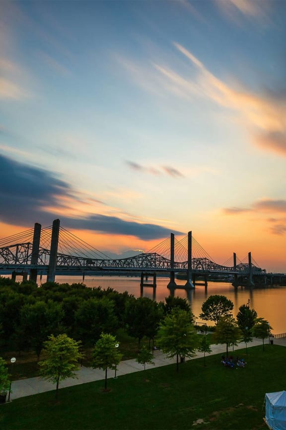 a view of a bridge over a river at sunset