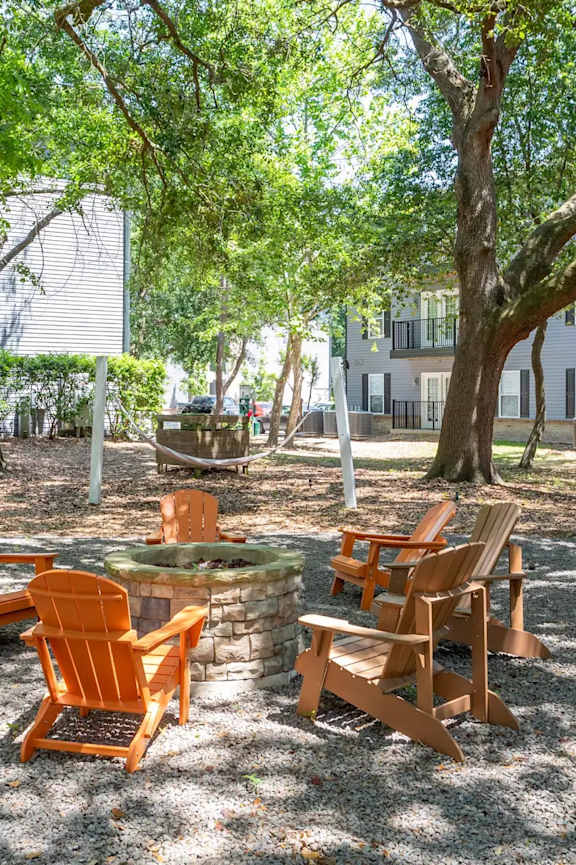 A sunny day at a park with chairs and tables.
