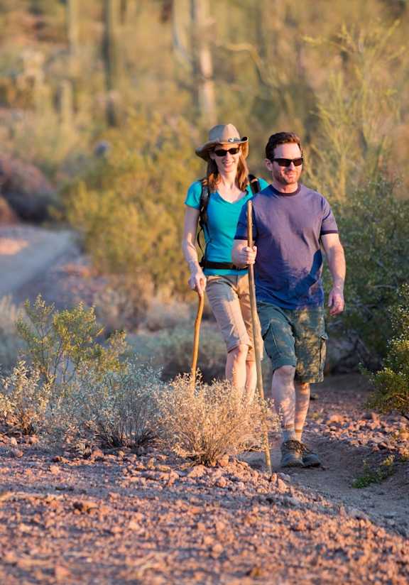 Man and Woman Walking on Path in Desert