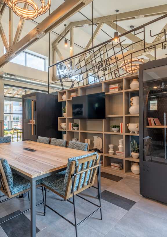 a large table and chairs in a room with a bookshelf